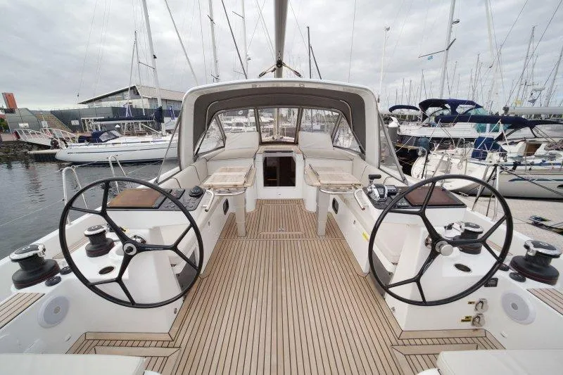  Yacht Photos Pics 2022 Beneteau Oceanis Yacht 54 cockpit with dual steering wheels, docked at marina.