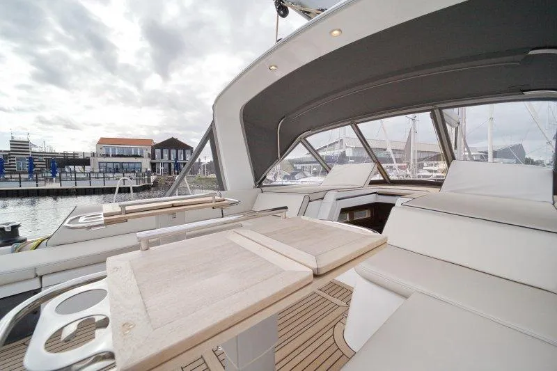  Yacht Photos Pics Luxurious 2022 Beneteau Oceanis Yacht 54 interior with elegant seating and wooden table.