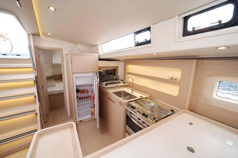  Yacht Photos Pics Luxurious interior of 2022 Beneteau Oceanis Yacht 54, featuring modern kitchen and cozy cabin.