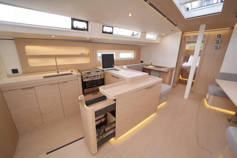  Yacht Photos Pics Luxurious interior of 2022 Beneteau Oceanis Yacht 54 with modern kitchen and seating area.