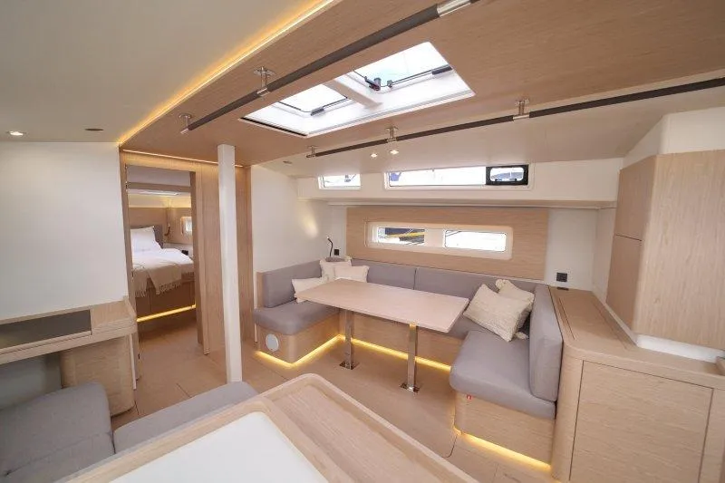  Yacht Photos Pics Luxurious interior of 2022 Beneteau Oceanis Yacht 54 with modern seating and dining area.