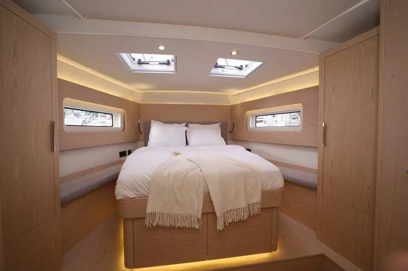  Yacht Photos Pics Luxurious cabin interior of 2022 Beneteau Oceanis Yacht 54 with cozy bed and modern design.
