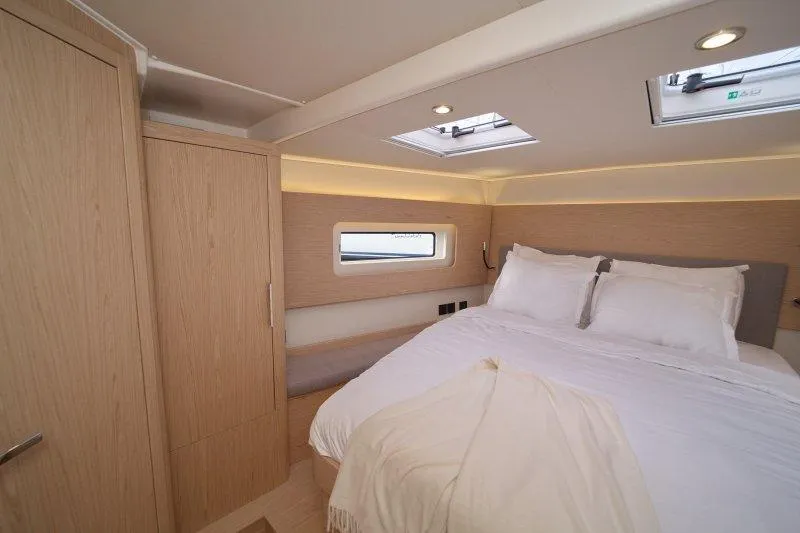  Yacht Photos Pics Luxurious cabin interior of 2022 Beneteau Oceanis Yacht 54 with cozy bed and modern design.
