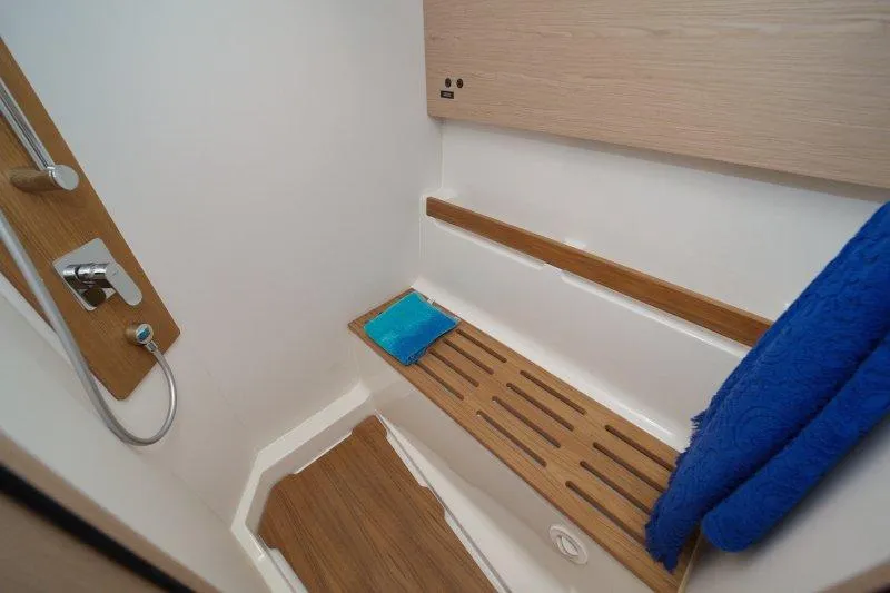  Yacht Photos Pics Luxurious bathroom in 2022 Beneteau Oceanis Yacht 54 with wooden accents and modern fixtures.