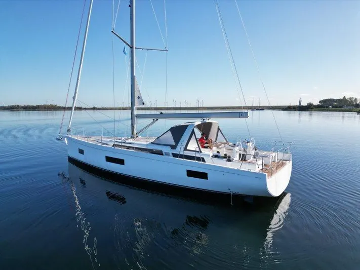  Yacht Photos Pics 2022 Beneteau Oceanis Yacht 54 sailing on calm waters under clear blue sky.