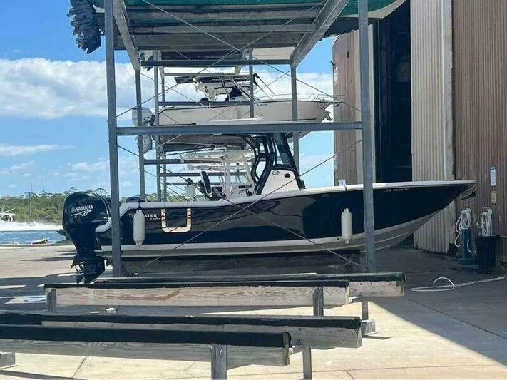  Yacht Photos Pics 2023 Tidewater 256 CC Adventure boat in storage, featuring a Yamaha outboard motor.