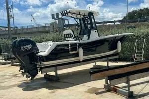  Yacht Photos Pics 2023 Tidewater 256 CC Adventure boat on a lift, featuring a sleek black and white design.