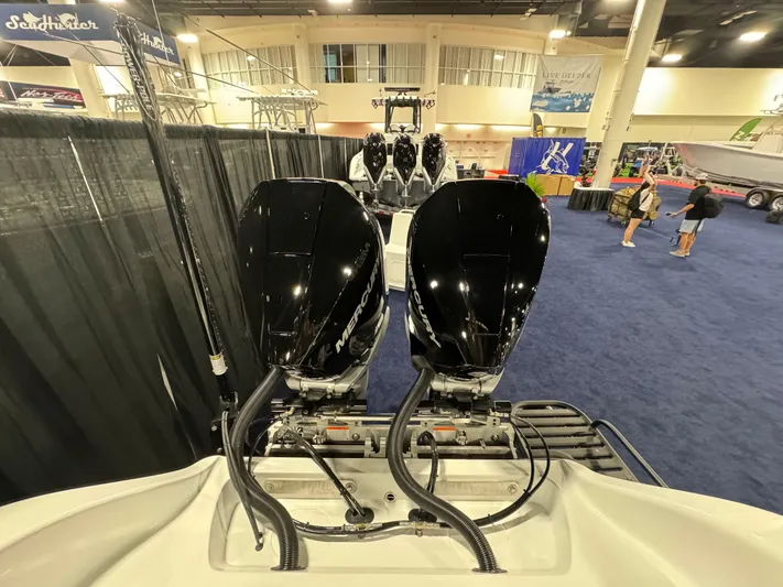  Yacht Photos Pics 2025 Yellowfin 26 Hybrid boat with dual outboard motors at indoor exhibition.