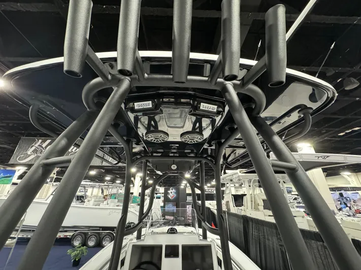  Yacht Photos Pics 2025 Yellowfin 26 Hybrid boat interior with rod holders and speakers at a boat show.