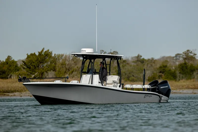  Yacht Photos Pics 2025 Yellowfin 26 Hybrid boat on water, side view with trees in background.