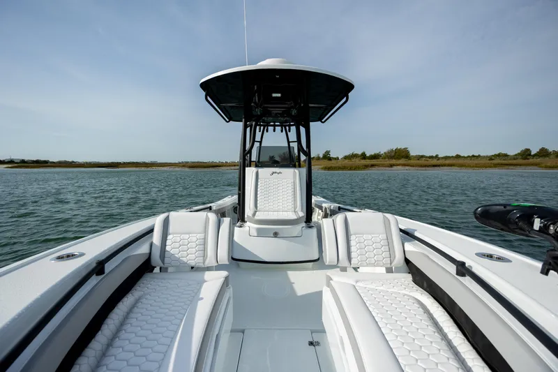  Yacht Photos Pics 2025 Yellowfin 26 Hybrid boat on calm water, featuring sleek design and spacious seating.