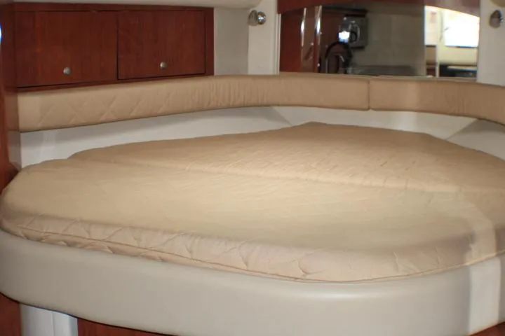 O Sea D Yacht Photos Pics 2007 Sea Ray 340 Sundancer cabin interior with beige bedding and wooden cabinets.