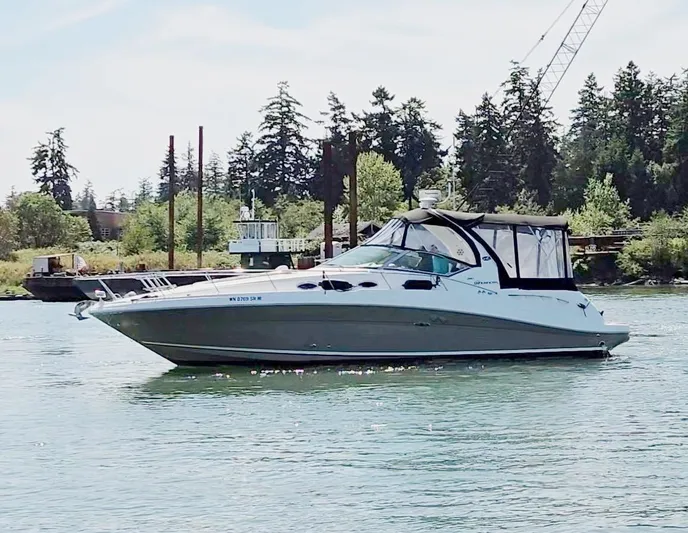 O Sea D Yacht Photos Pics 2007 Sea Ray 340 Sundancer yacht on calm water, surrounded by trees and industrial structures.