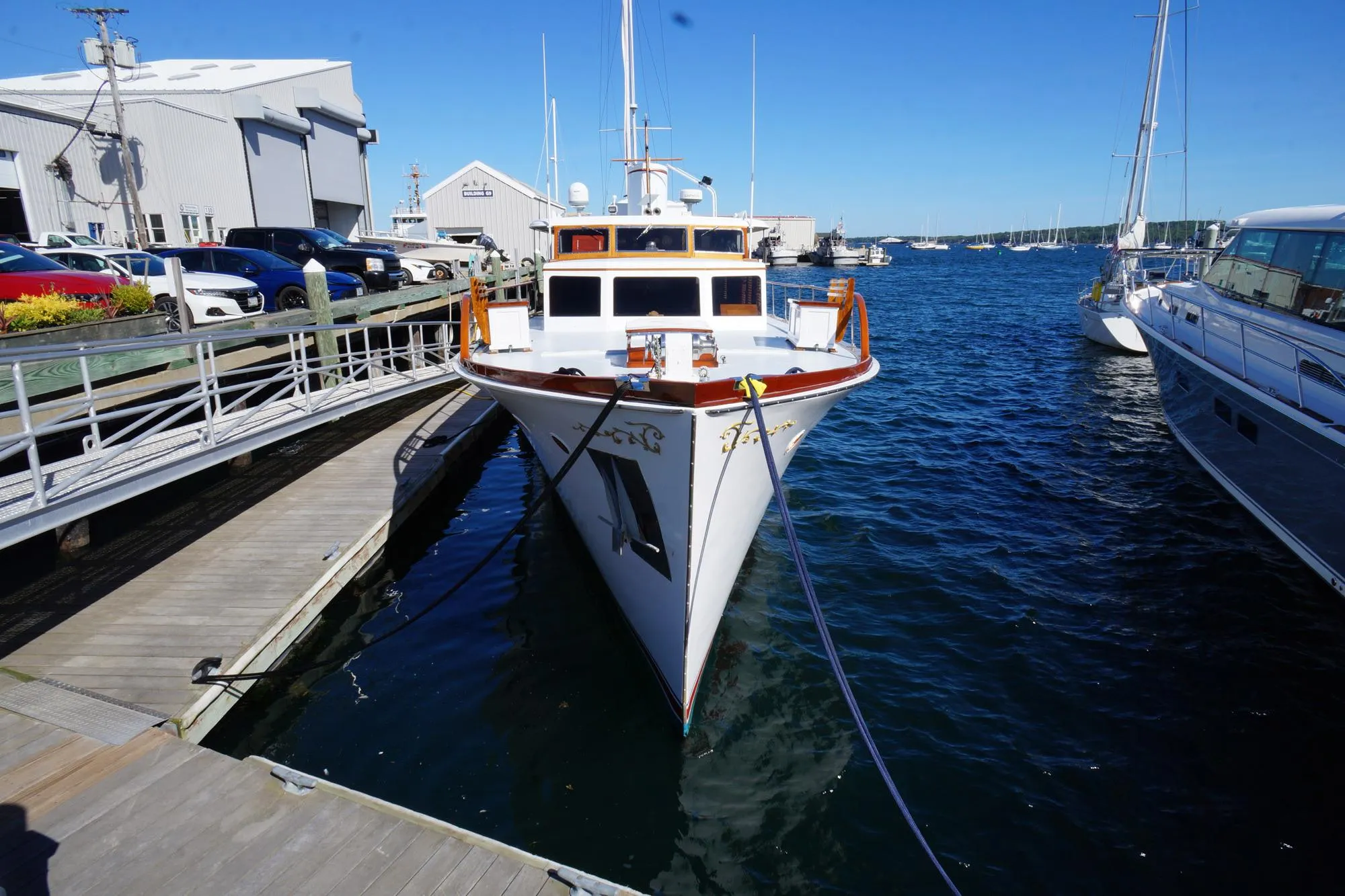 1954 Trumpy 68 Motor Yacht docked at marina on a sunny day.