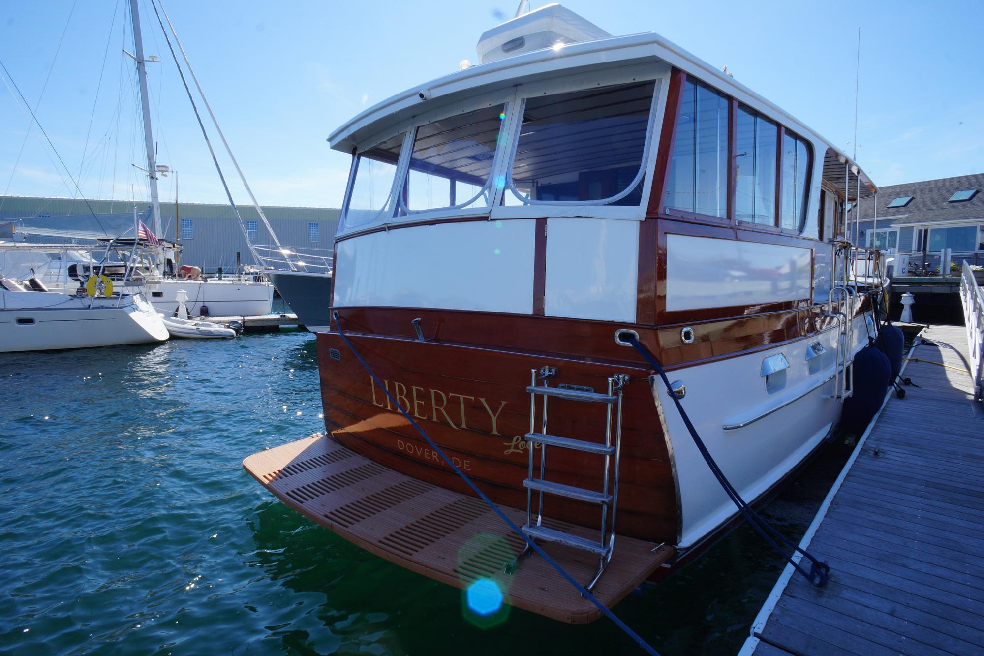 1954 Trumpy 68 Motor Yacht docked, featuring classic wooden design and elegant finish.
