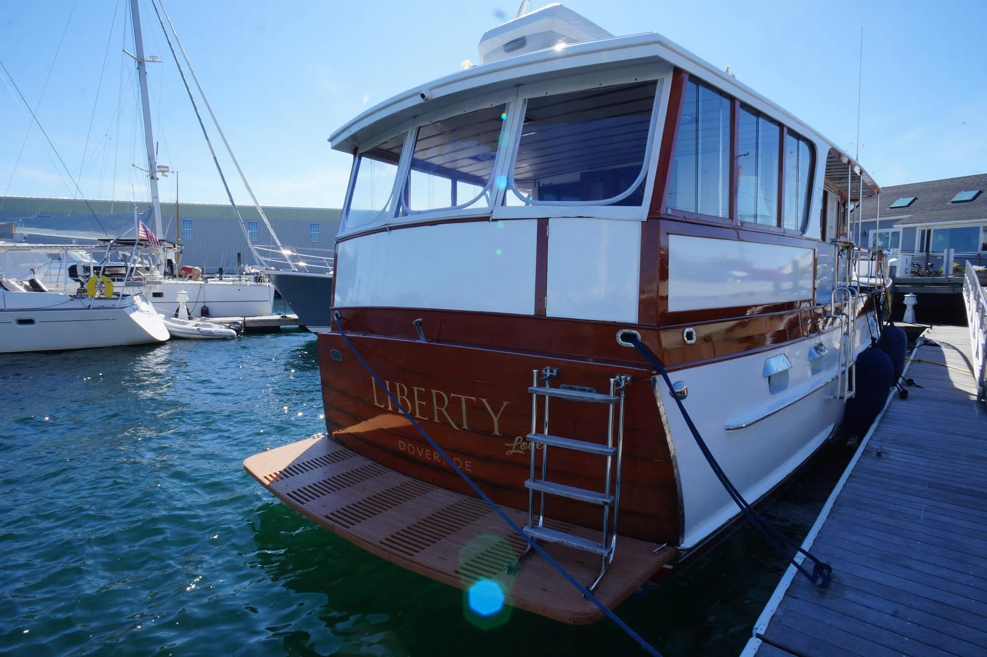 1954 Trumpy 68 Motor Yacht docked, featuring classic wooden design and elegant finish.
