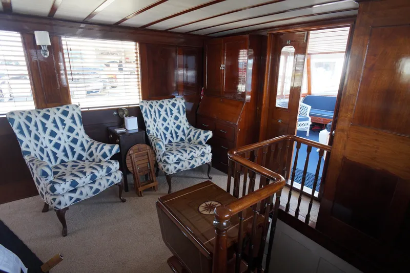 Liberty Love Yacht Photos Pics Luxurious 1954 Trumpy 68 Motor Yacht interior with elegant wood paneling and patterned armchairs.