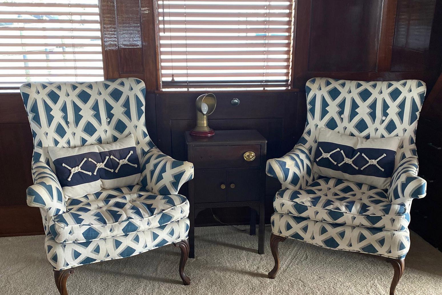 Two patterned armchairs with nautical pillows on a 1954 Trumpy 68 Motor Yacht.