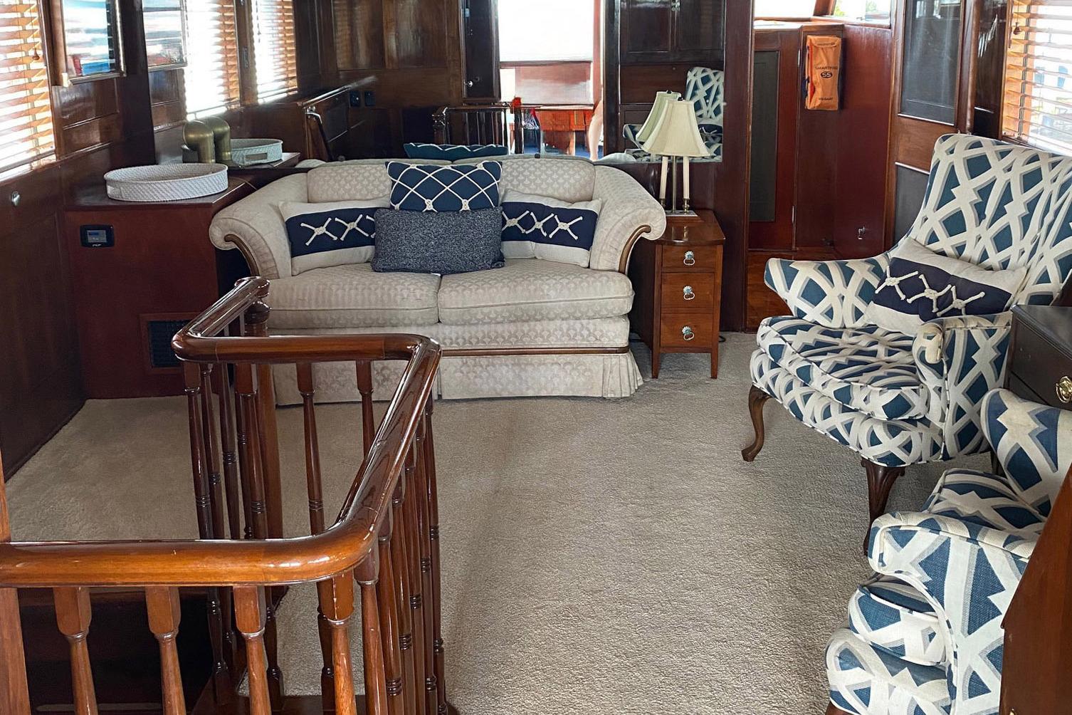 Luxurious interior of a 1954 Trumpy 68 Motor Yacht with elegant seating and wooden accents.