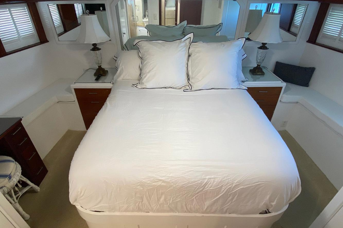 Luxurious bedroom interior of 1954 Trumpy 68 Motor Yacht with elegant decor and cozy bedding.