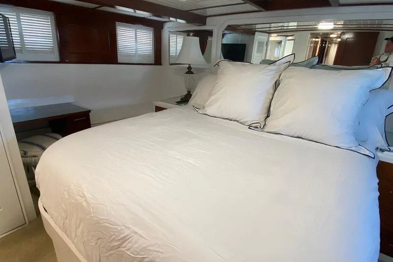 Liberty Love Yacht Photos Pics Luxurious bedroom interior of 1954 Trumpy 68 Motor Yacht with elegant bedding and wooden accents.