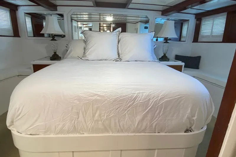 Liberty Love Yacht Photos Pics Luxurious bedroom interior of 1954 Trumpy 68 Motor Yacht with elegant bedding and lamps.
