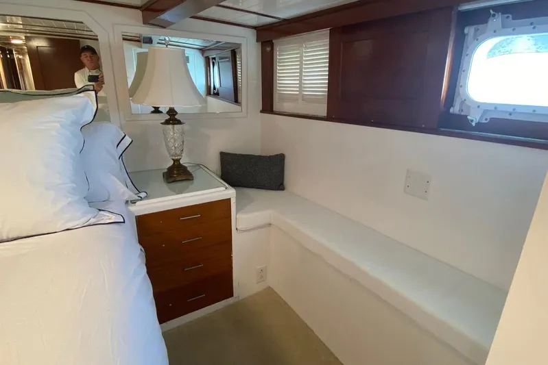 Liberty Love Yacht Photos Pics Interior of 1954 Trumpy 68 Motor Yacht with bed, lamp, and porthole window.