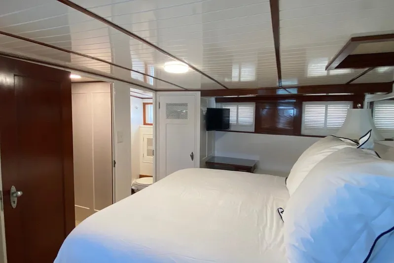 Liberty Love Yacht Photos Pics Luxurious bedroom interior of 1954 Trumpy 68 Motor Yacht with elegant wood paneling.