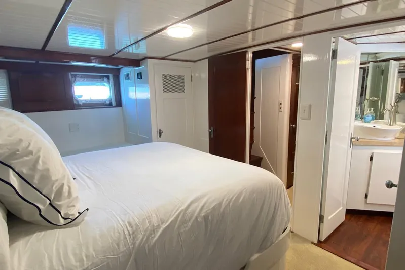 Liberty Love Yacht Photos Pics Cozy bedroom in 1954 Trumpy 68 Motor Yacht with white bedding and wooden accents.