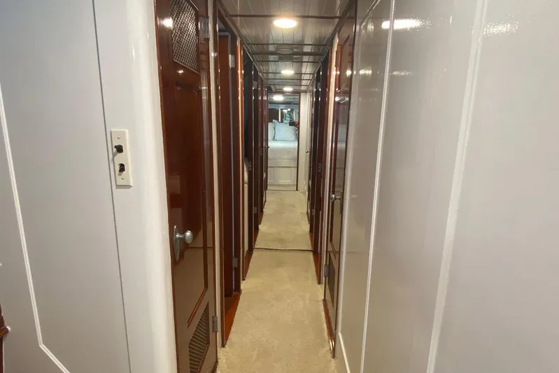 Liberty Love Yacht Photos Pics Hallway inside 1954 Trumpy 68 Motor Yacht, featuring wooden doors and carpeted floor.