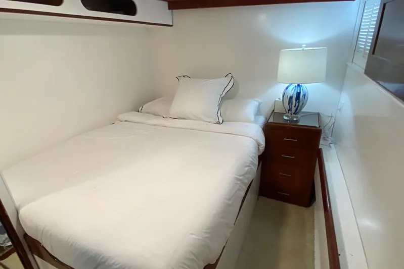 Liberty Love Yacht Photos Pics Cozy bedroom on 1954 Trumpy 68 Motor Yacht with elegant decor and soft lighting.