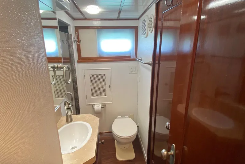 Liberty Love Yacht Photos Pics Bathroom interior of 1954 Trumpy 68 Motor Yacht with wooden accents and modern fixtures.