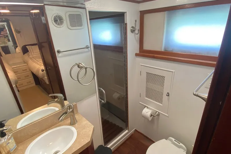 Liberty Love Yacht Photos Pics Bathroom interior of 1954 Trumpy 68 Motor Yacht with sink, shower, and toilet.