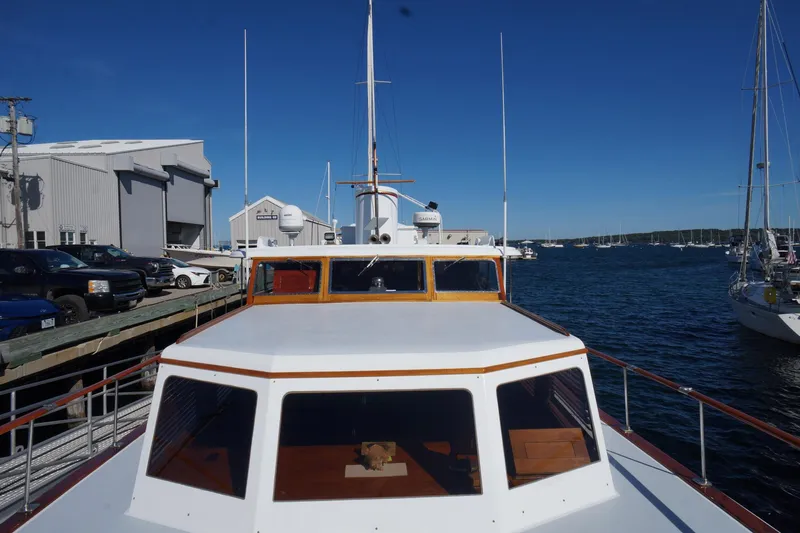 Liberty Love Yacht Photos Pics 1954 Trumpy 68 Motor Yacht docked at marina, clear blue sky, and surrounding boats.