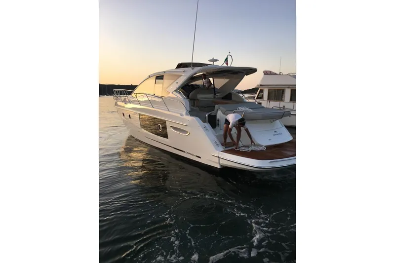  Yacht Photos Pics 2017 Cranchi M 44 HT yacht at sunset, person handling ropes on deck.