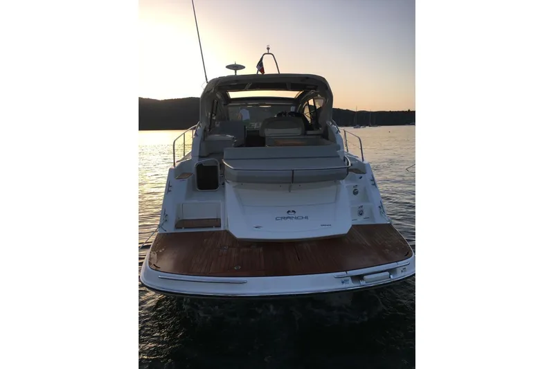  Yacht Photos Pics 2017 Cranchi M 44 HT yacht at sunset, rear view on calm water.