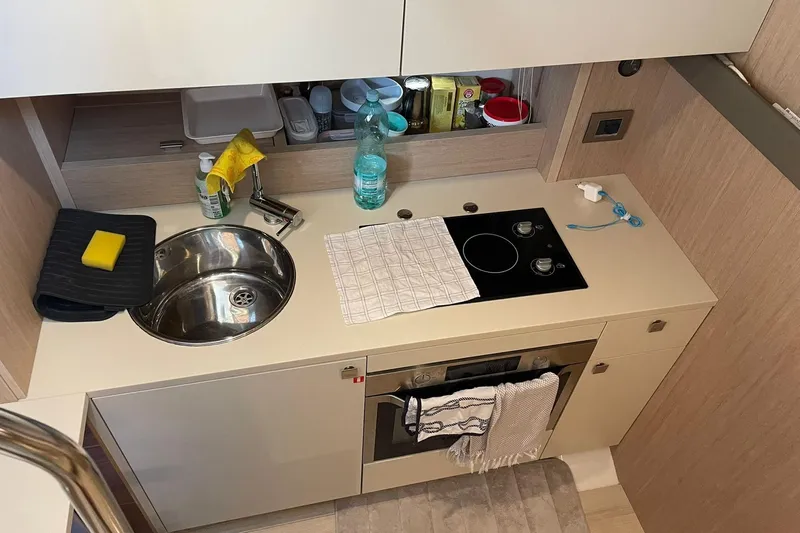  Yacht Photos Pics Compact kitchen area in a 2017 Cranchi M 44 HT yacht with sink and stove.