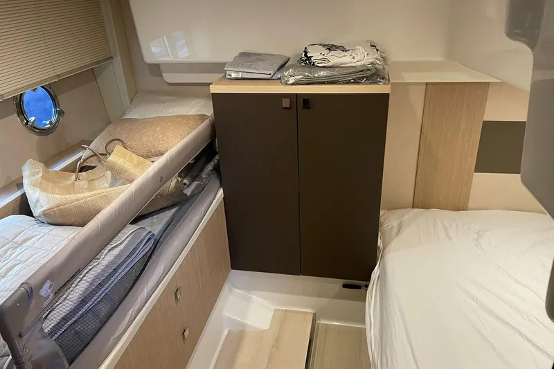  Yacht Photos Pics 2017 Cranchi M 44 HT cabin interior with beds, storage, and porthole window.