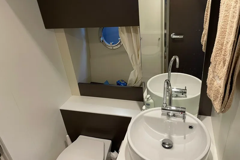  Yacht Photos Pics Bathroom interior of 2017 Cranchi M 44 HT yacht with sink, mirror, and porthole.