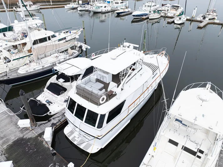  Yacht Photos Pics 1980 Hatteras 53 Motor Yacht docked in a marina, surrounded by other boats.
