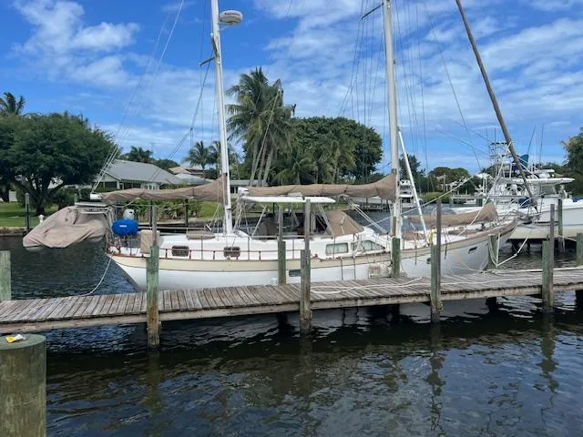 1981 Hardin Voyager 45 Ketch docked by palm trees under blue sky.