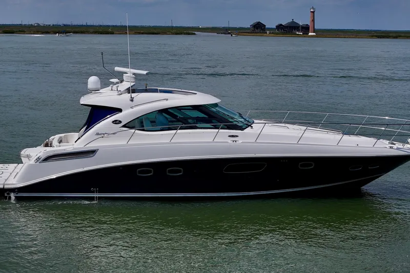 La Vie En Rose Yacht Photos Pics 2009 Sea Ray 470 Sundancer yacht cruising on calm waters near a lighthouse.