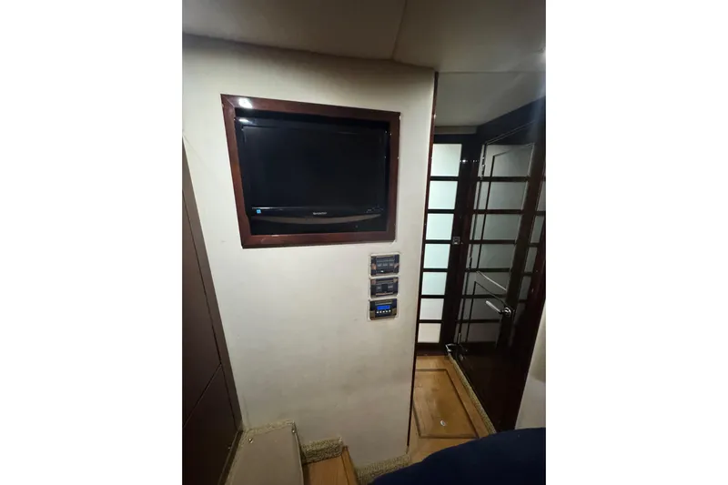 La Vie En Rose Yacht Photos Pics Interior of 2009 Sea Ray 470 Sundancer with wall-mounted TV and control panels.