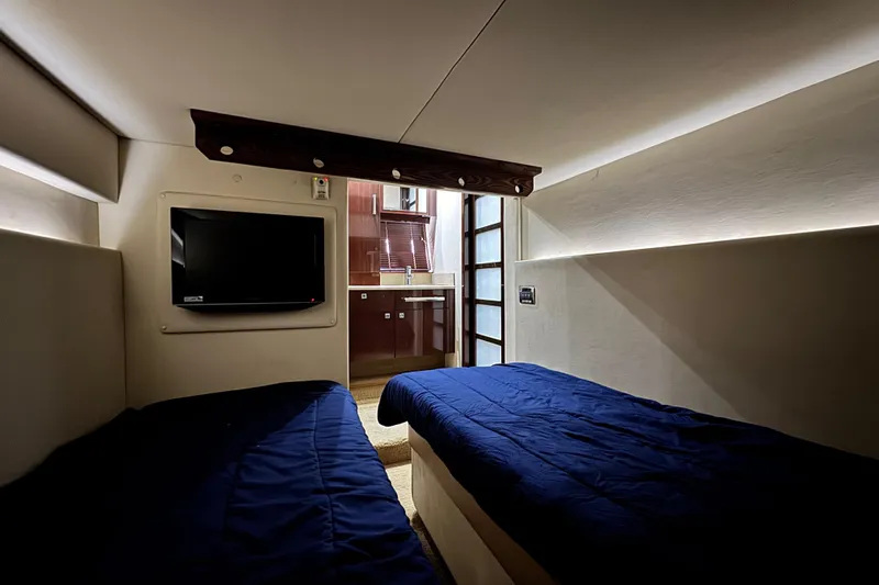 La Vie En Rose Yacht Photos Pics Interior of 2009 Sea Ray 470 Sundancer with twin beds and wall-mounted TV.