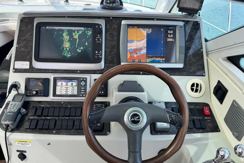 La Vie En Rose Yacht Photos Pics Control panel of a 2009 Sea Ray 470 Sundancer with navigation screens and steering wheel.