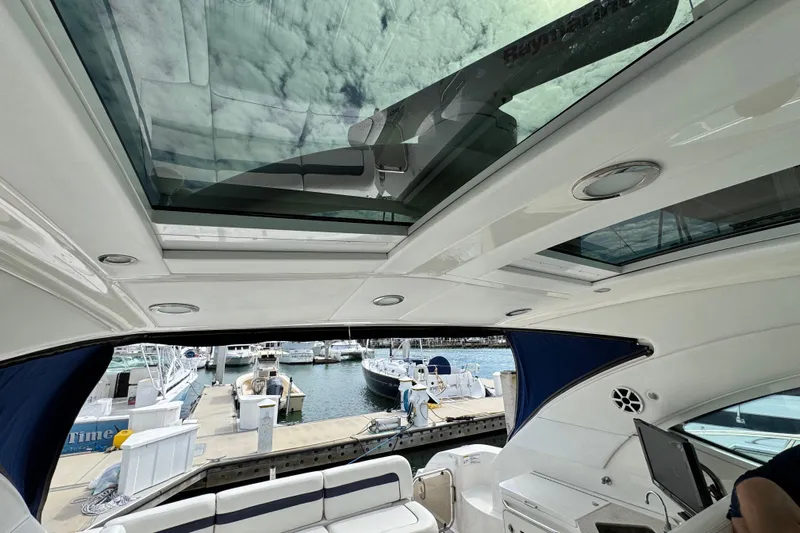 La Vie En Rose Yacht Photos Pics Interior view of 2009 Sea Ray 470 Sundancer yacht with open sunroof and marina backdrop.