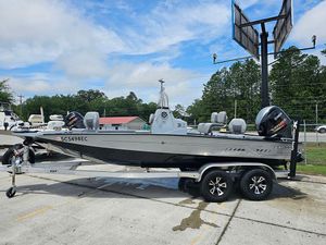 2023 Xpress H20B boat on trailer, parked outdoors under cloudy sky.
