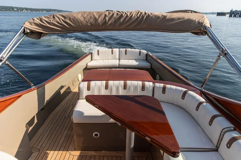 Fiveadrift Yacht Photos Pics 2003 Hinckley Talaria 29R boat interior with elegant seating and wooden table on calm water.