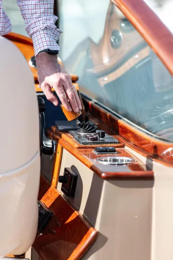 Fiveadrift Yacht Photos Pics Man operating controls on a 2003 Hinckley Talaria 29R boat with wooden dashboard.