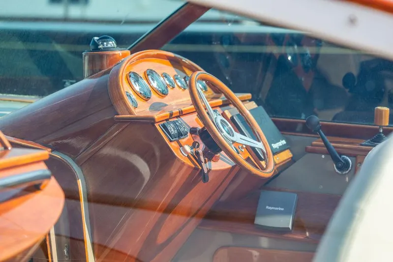 Fiveadrift Yacht Photos Pics Interior of a 2003 Hinckley Talaria 29R boat, featuring a classic wooden dashboard and steering wheel.